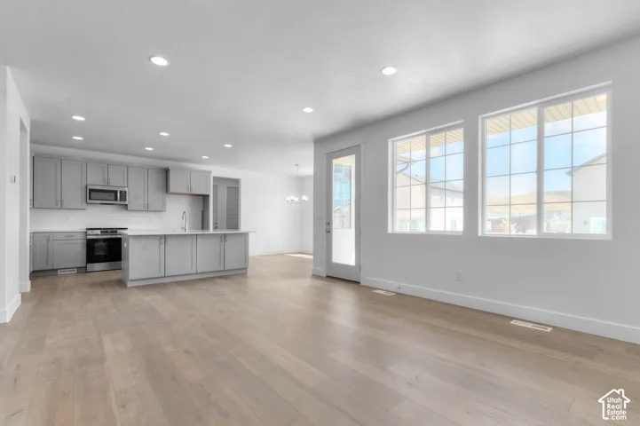 Kitchen featuring grey cabinetry, stainless steel appliances, and a center island