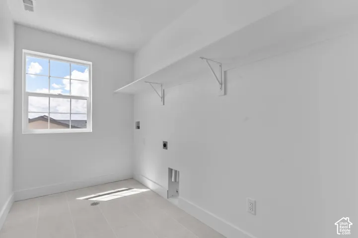 Utility room featuring tile flooring, a single-hung window, and wall-mounted shelving with support brackets