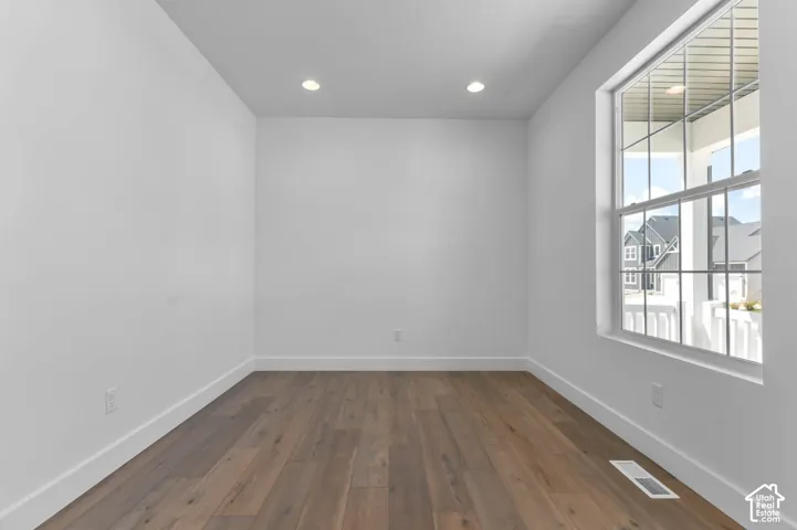 Interior room featuring wood-finish flooring, recessed lighting, and a window with mullions