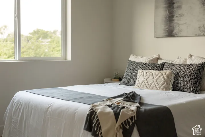 Neutral-toned interior space featuring a large window with exterior greenery