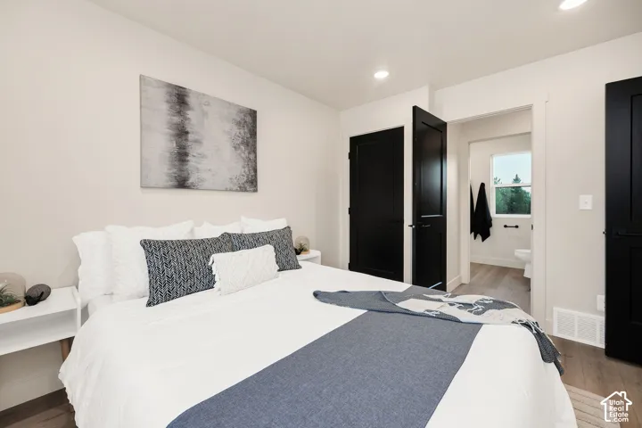 Neutral-toned interior featuring recessed lighting, high-contrast black interior doors, wood-finish flooring, and crisp white wall trim