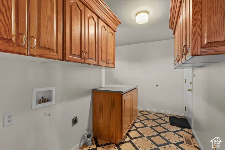 Wood-finish upper and lower cabinetry, built-in countertop, patterned tile flooring, and ceiling-mounted dome light fixture