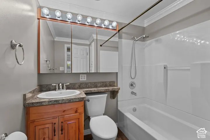 Bathroom featuring a natural wood-finish vanity, stone-surface countertop with an integrated basin, triple-panel mirrored medicine cabinet with integrated lighting, and a bathtub-shower combination with a surround enclosure