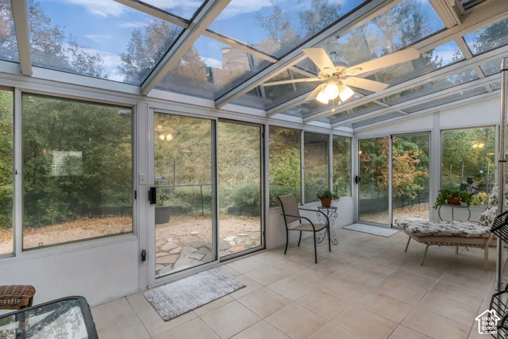Four Seasons Sunroom featuring a glass-paneled ceiling, floor-to-ceiling glass walls, multiple sliding glass doors, ceramic tile flooring, water, heat and AC