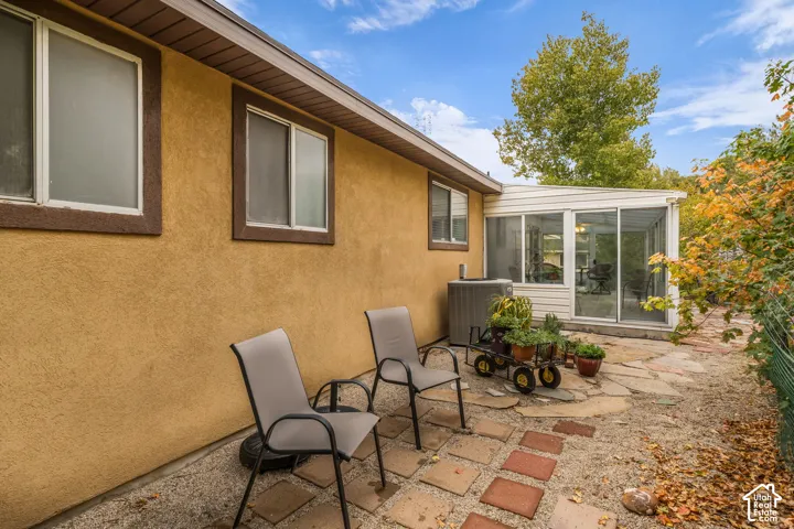 Stucco exterior featuring dual-pane sliding windows and an enclosed sunroom with glass walls