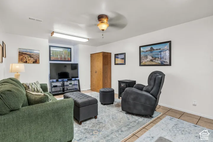 Neutral interior featuring ceramic tile flooring, built-in wooden cabinetry, a ceiling fan, and recessed lighting