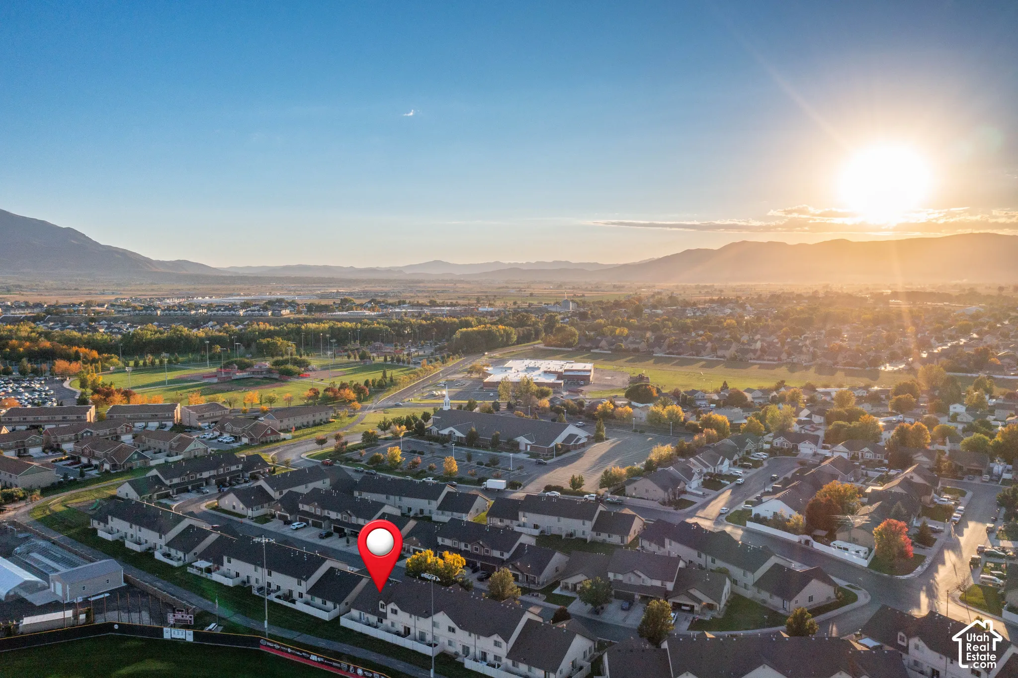 Aerial perspective showcasing proximity to open green space, community infrastructure, and mountain topography