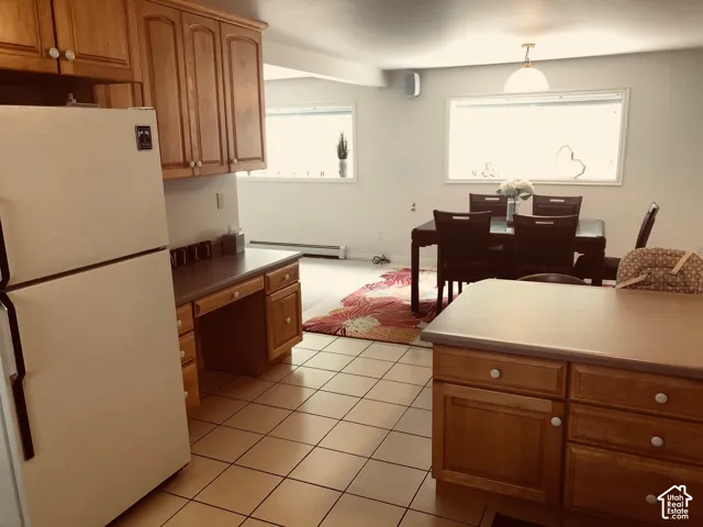 Kitchen with tile flooring and wood-finish cabinetry