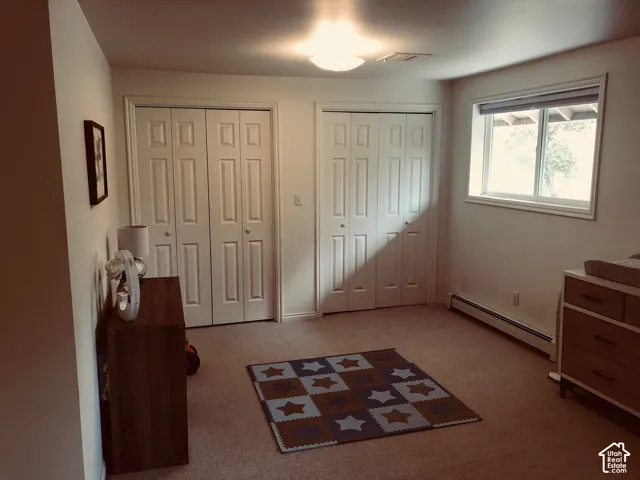 2nd Home. Interior room featuring two sets of dual-panel closet doors, neutral carpeting, and a single-pane window
