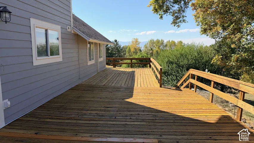 Spacious wood-finish deck with railings, offering an outdoor living area
