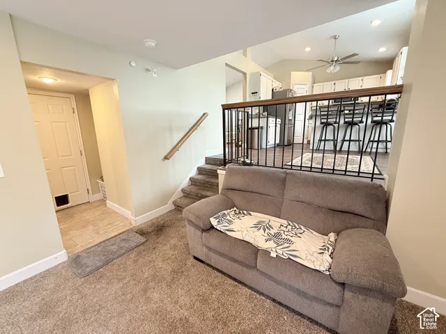 Interior space featuring wall-to-wall carpeting, metal railing with wood-finish handrail, recessed lighting, and a ceiling fan