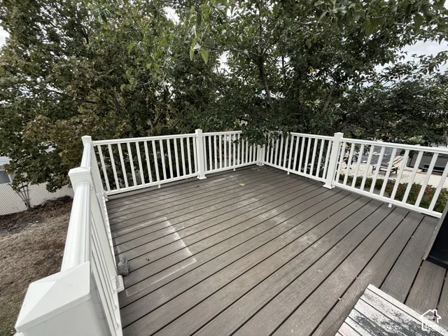 Elevated deck featuring composite decking planks and white vertical balustrade railing