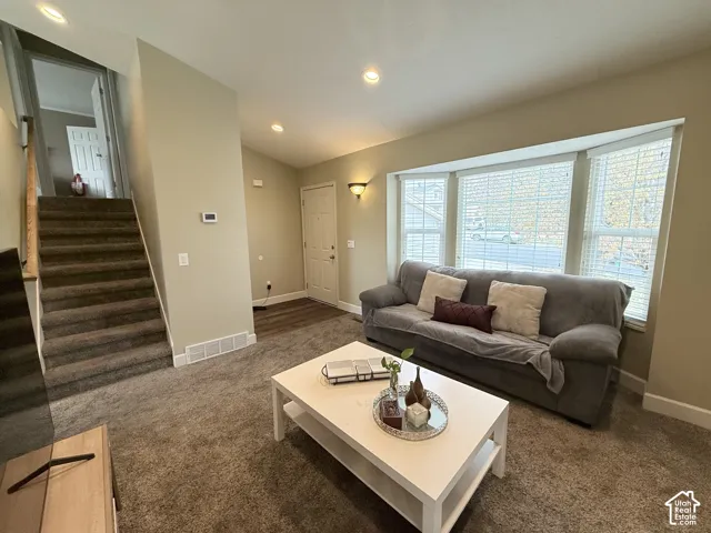 Interior space featuring a bay window, neutral wall paint, recessed lighting, and carpeted flooring