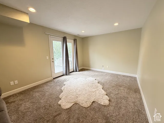 Neutral-toned interior featuring recessed lighting, wall-to-wall carpeting, and a glass-paneled exterior door
