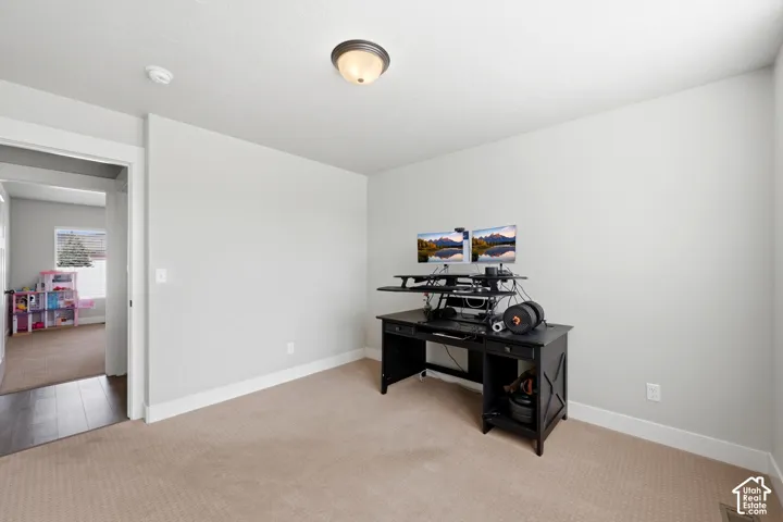 Neutral-toned interior space featuring wall-to-wall carpeting and a central flush-mount dome light fixture