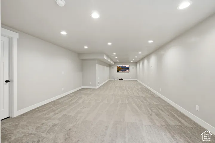 Neutral-toned interior space featuring wall-to-wall carpeting, recessed ceiling lighting, and a neutral paint palette