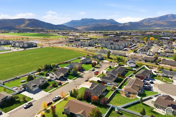 Aerial perspective of residential neighborhood featuring expansive green space and mountain topography