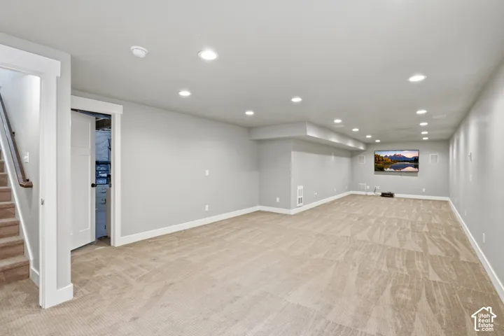 Open floor plan featuring wall-to-wall carpeting, recessed ceiling lighting, and neutral wall paint