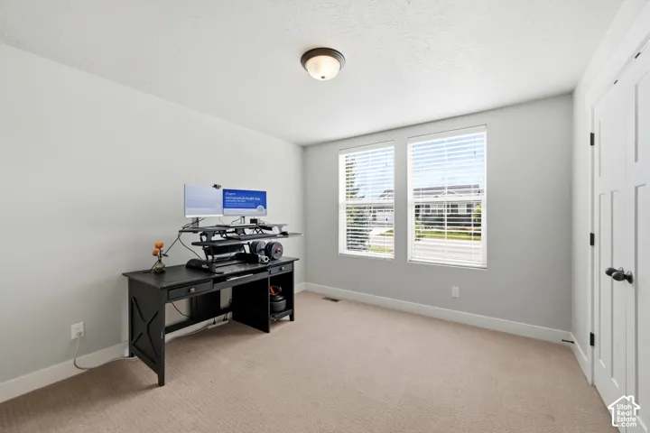Neutral-toned walls, plush wall-to-wall carpeting, dual-pane windows with horizontal blinds, and a six-panel interior door
