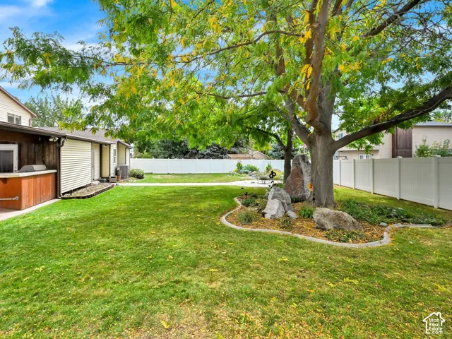 Expansive grassy yard with mature tree landscaping