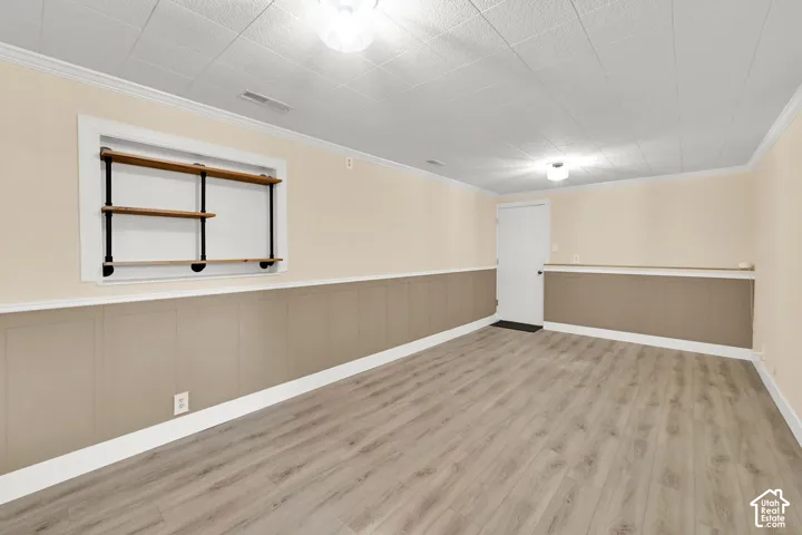 Wood-finish flooring, wall-mounted shelving, overhead lighting, and two-tone wall paneling