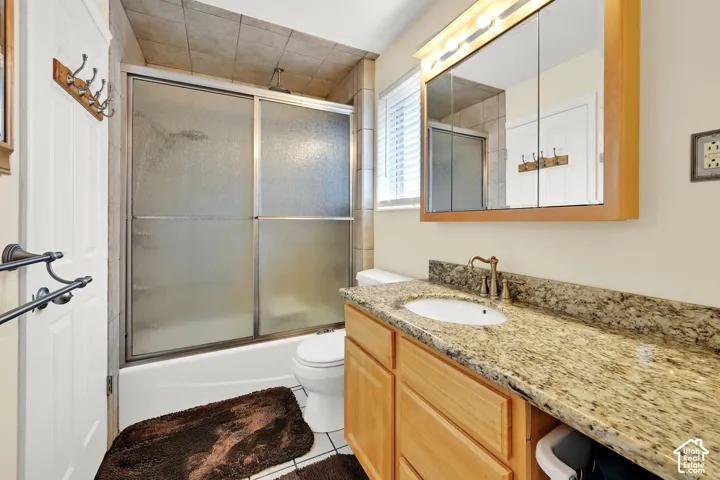 Built-in vanity with light wood-finish cabinetry, a granite-style countertop, and an integrated basin