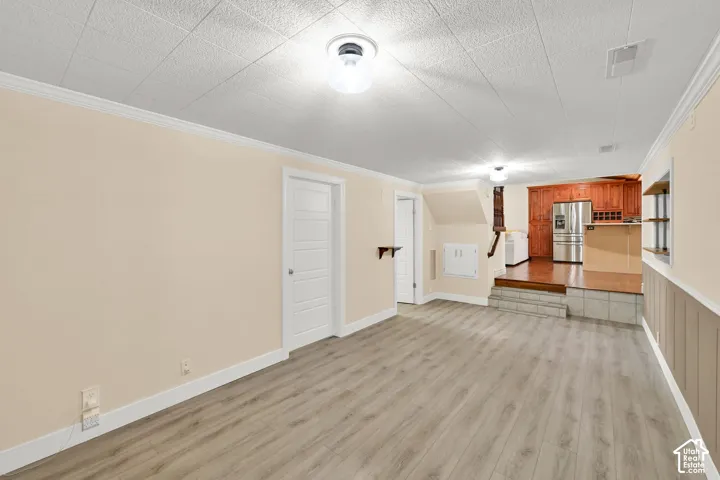 Spacious open-concept living area featuring wood-finish plank flooring, recessed ceiling lighting, and white trim throughout