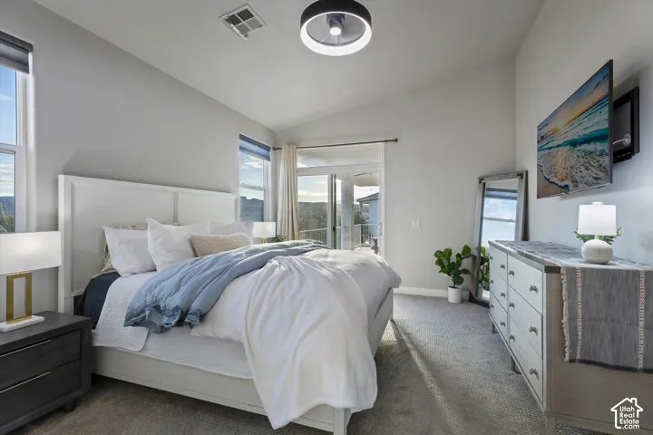 Primary Bedroom: Vaulted ceilings, soft carpet, and a slider straight out to the covered deck.