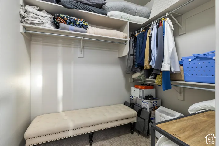 Primary Closet: A walk-in closet with shelving and double hanging rods.