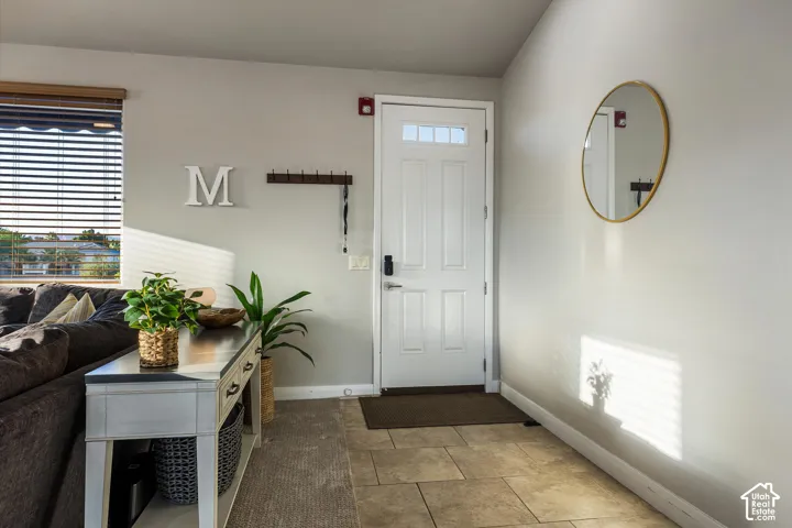Entry: A tiled entry with a keypad smart lock and coat hooks, just off the living room.