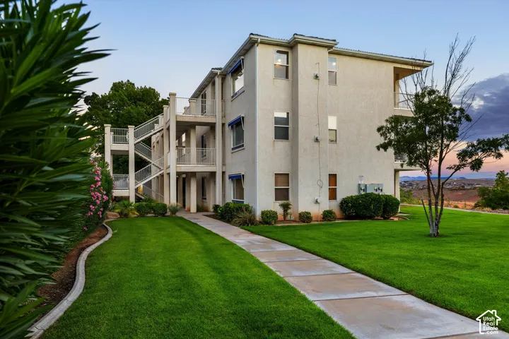 Exterior: A landscaped lawn and walkway lead to the building at dusk.