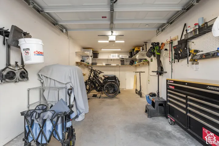Garage: Inside the detached garage, with an opener, overhead lighting, and wall storage.