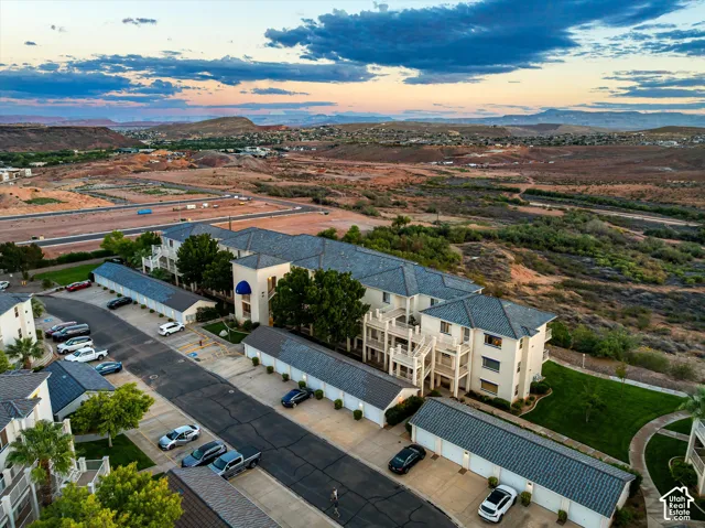 Aerial: The building, its garage rows, and the parking area, with desert beyond.