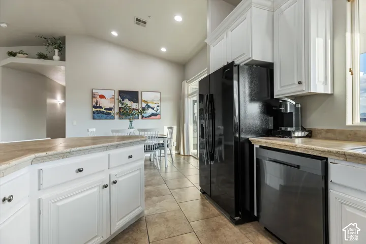 Kitchen: Plenty of white cabinetry and counter space, open to the dining area and the hallway.
