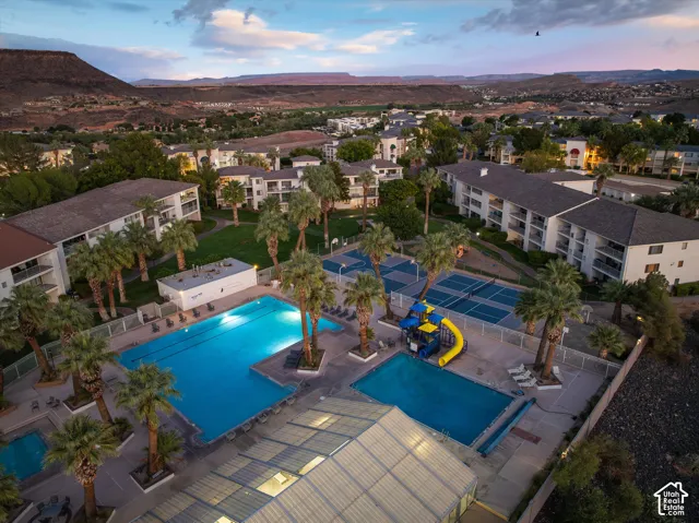 Aerial: Pools, the giant double waterslide, and pickleball and basketball courts, all just steps from the buildings.