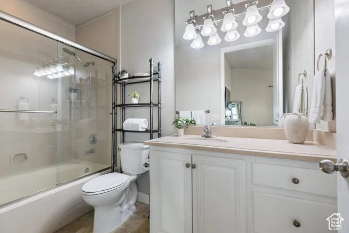 Primary Bathroom: A glass-door tub/shower, a vanity with storage, and a bright light bar.