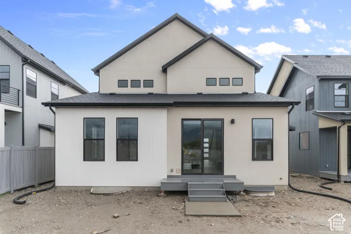 Exterior featuring a combination of stucco and vertical siding, dark-framed windows, a multi-gabled roofline, and an elevated concrete patio with stairs