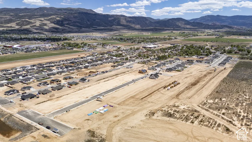Aerial perspective of residential development featuring paved streets and proximity to mountain scenery