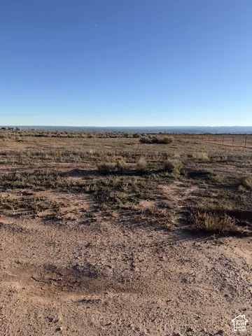 Expansive level acreage featuring native desert vegetation, wire fencing, and distant mountain backdrops
