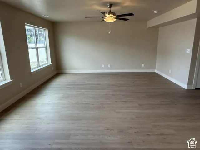 Wood-finish flooring, dual-pane windows, and a central ceiling fan with integrated lighting