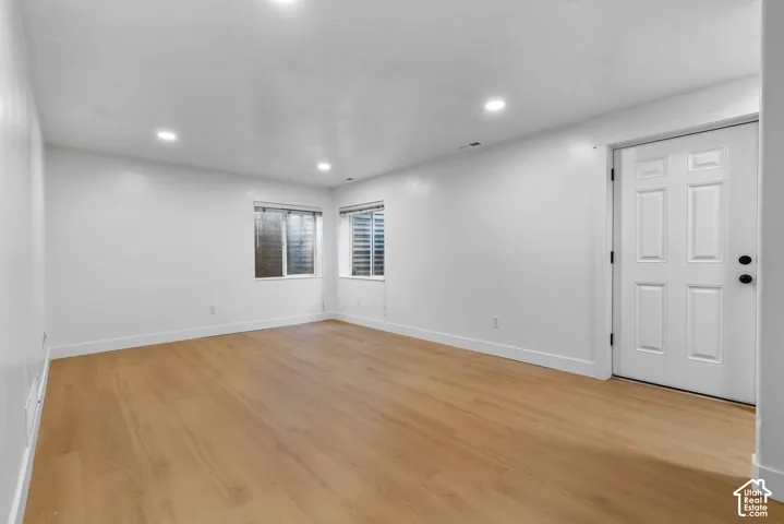 Interior space featuring wood-finish flooring, recessed lighting, and a six-panel door