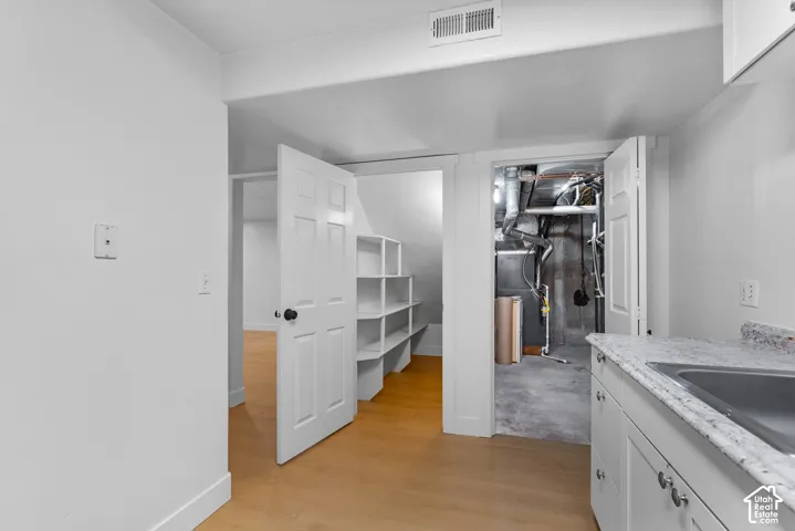 Cabinetry with stone-composite countertops, integrated sink, and built-in shelving