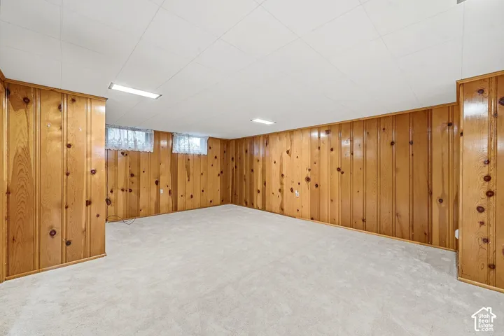 Paneled wood walls, neutral carpeting, recessed ceiling lighting, and horizontal sliding windows