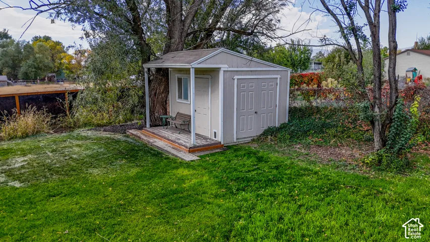 Exterior storage shed with a covered porch, single window, and double doors