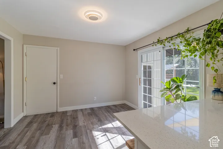 Wood-finish flooring, sliding glass door, overhead flush mount lighting, and a white countertop