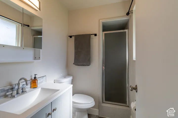 Single vanity with integrated sink, chrome faucet, and tiled backsplash