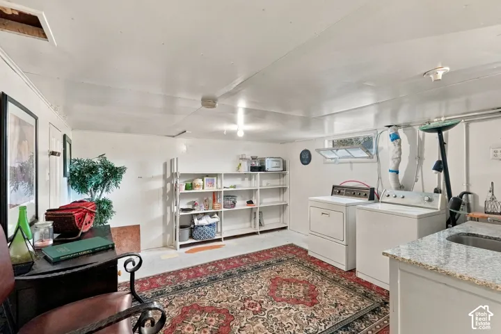 Utility area featuring stone-finish countertop, integrated stainless steel sink, built-in open metal shelving, and a hopper window
