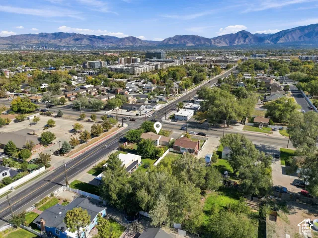 Aerial perspective highlighting a corner lot location with mature trees and mountain scenery