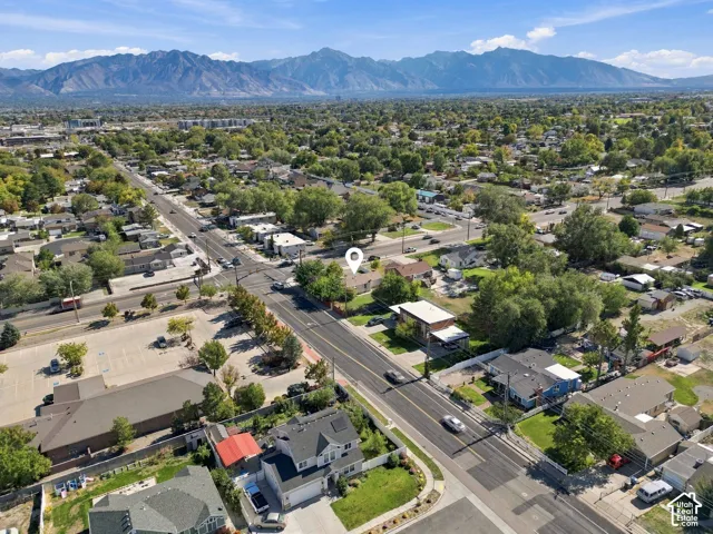 Aerial perspective of the property featuring a single-story residence, a large lot, and prominent mountain range backdrop