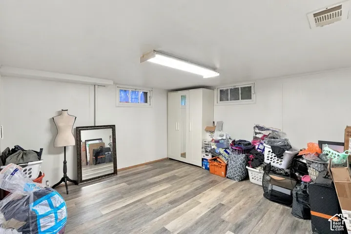 Wood-finish flooring, two horizontal windows, and ceiling-mounted light fixture